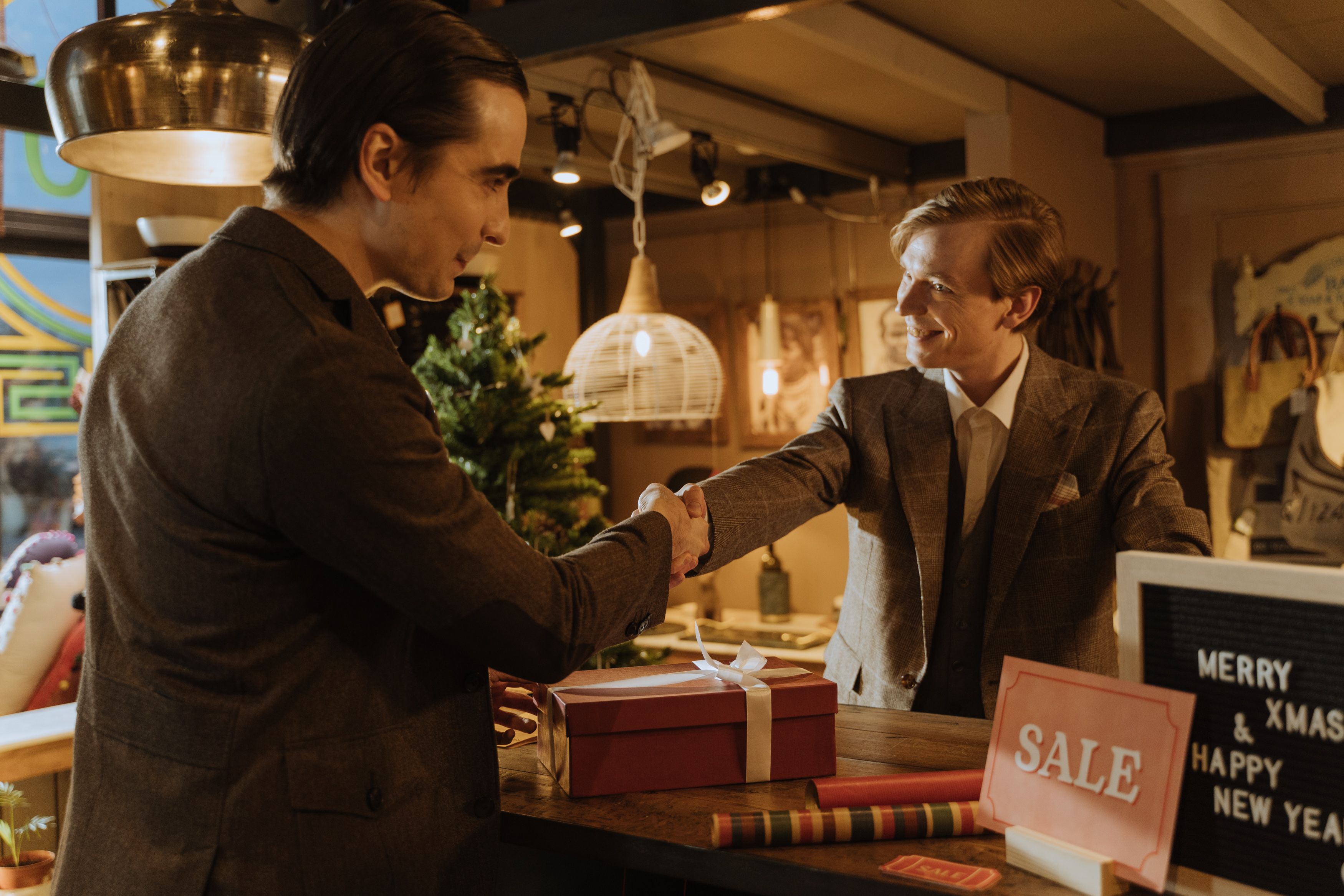 Two people shaking hands at a retail counter